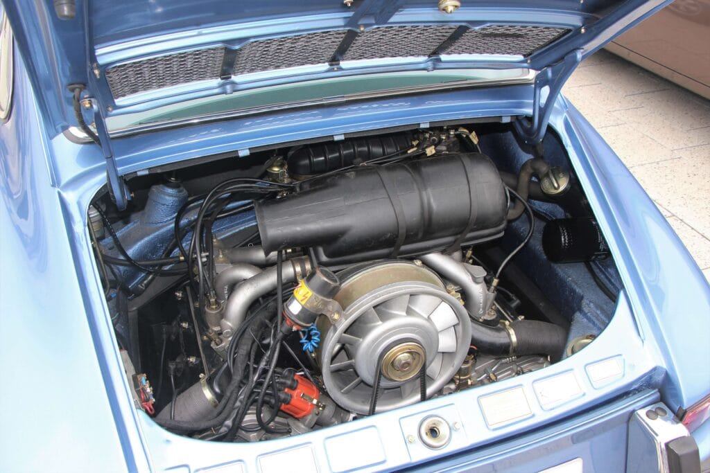 Rear-mounted Porsche 911 engine bay showing belts, fan, and wiring, used to demonstrate safe trap placement points for rodent control