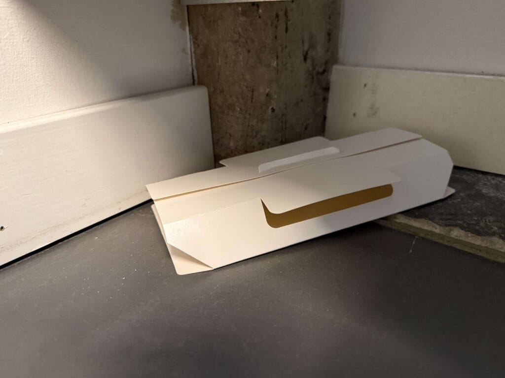 Sticky trap placed against a wall in a corner for monitoring silverfish activity